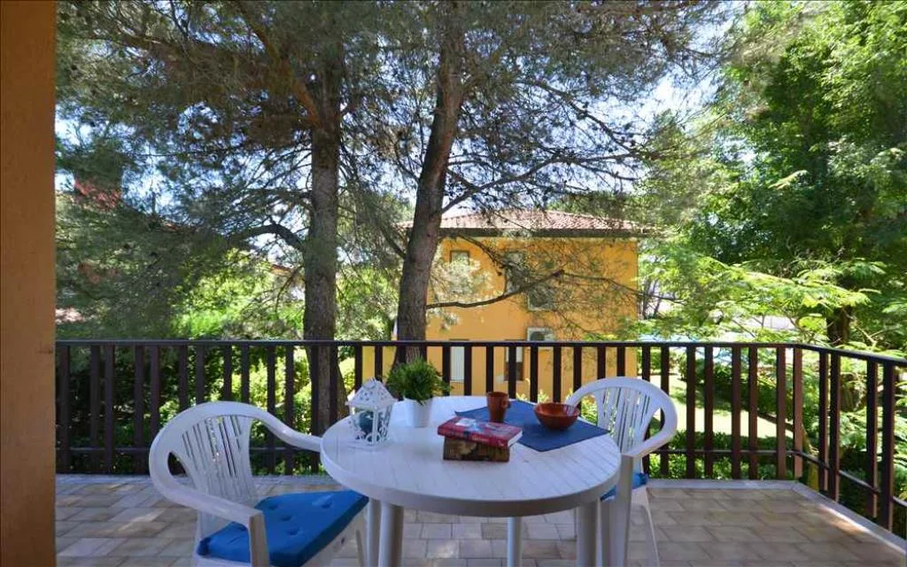 Terrazza con tavolo e sedie immersa nel verde tra i pini